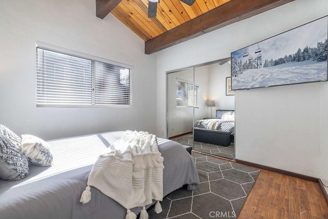 bedroom with dark hardwood / wood-style flooring, lofted ceiling with beams, a closet, and wooden ceiling