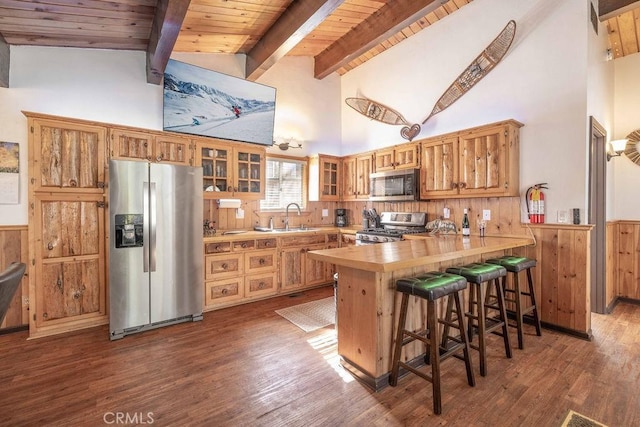 kitchen featuring a breakfast bar, sink, wooden ceiling, kitchen peninsula, and stainless steel appliances