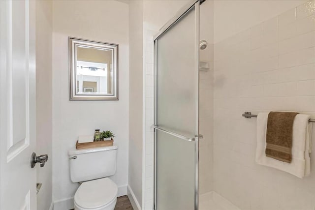 bathroom with an enclosed shower and toilet