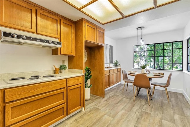 kitchen with hanging light fixtures, white electric cooktop, and light hardwood / wood-style floors