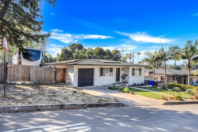 single story home with a garage and solar panels