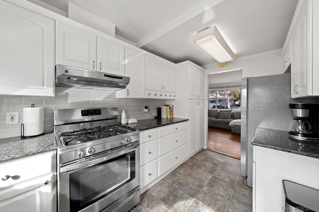 kitchen with white cabinetry, appliances with stainless steel finishes, decorative backsplash, and dark stone counters