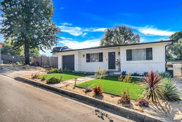 ranch-style home featuring a garage and a front lawn