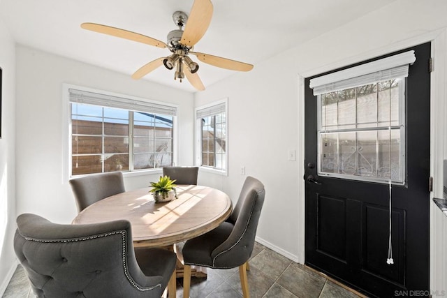 dining room with dark tile patterned flooring and ceiling fan