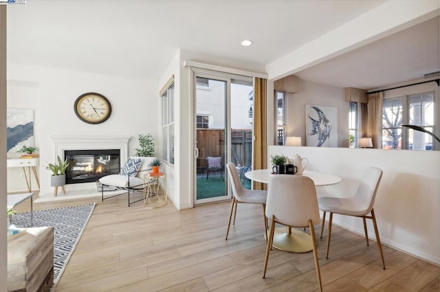 dining space featuring beam ceiling and light wood-type flooring