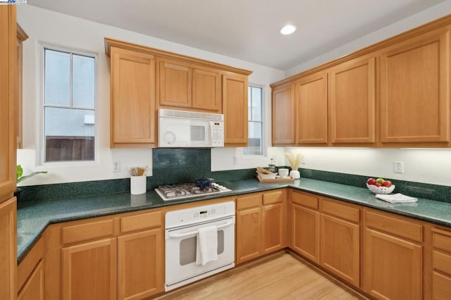 kitchen featuring white appliances, a wealth of natural light, and light hardwood / wood-style floors