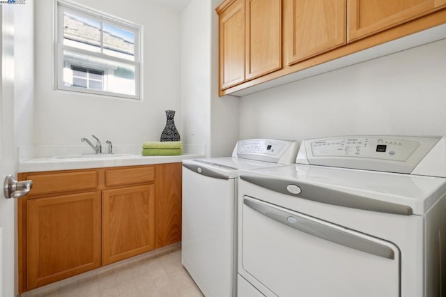 clothes washing area with cabinets, sink, and washing machine and clothes dryer