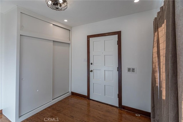 unfurnished bedroom with dark wood-type flooring and a closet