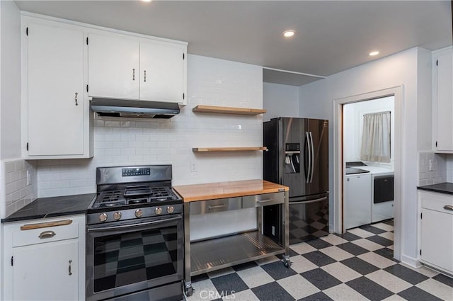 kitchen with white cabinets, decorative backsplash, stainless steel gas range oven, washing machine and dryer, and black refrigerator with ice dispenser