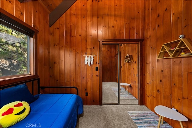 carpeted bedroom featuring wooden walls and vaulted ceiling