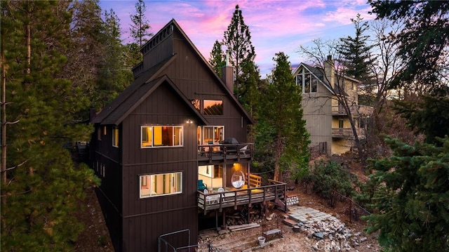 back house at dusk with a balcony