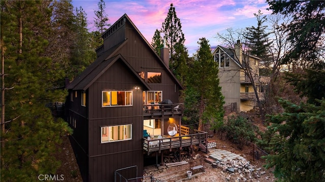 back of house with a chimney and a deck