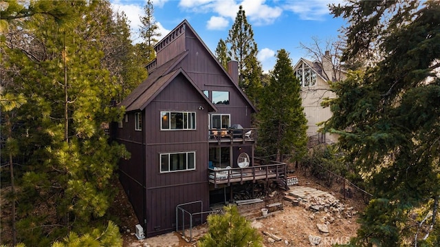 rear view of property featuring a chimney and a deck