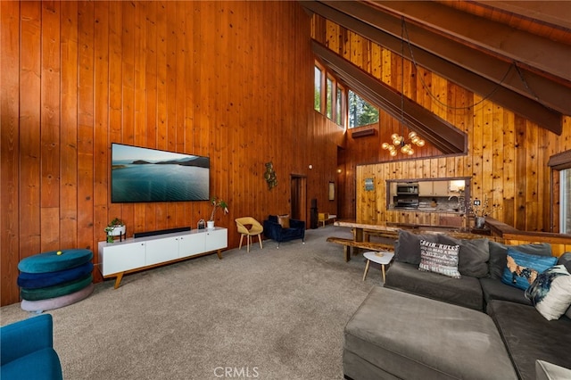 carpeted living room featuring a towering ceiling, beam ceiling, and wood walls