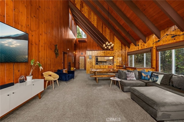 carpeted living room with beam ceiling, wooden walls, high vaulted ceiling, and a wealth of natural light