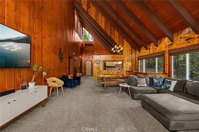 carpeted living room with wood walls, beam ceiling, a healthy amount of sunlight, and high vaulted ceiling