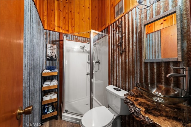 full bathroom with toilet, visible vents, a sink, and a stall shower