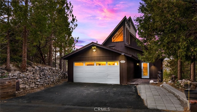 chalet / cabin with an attached garage and driveway