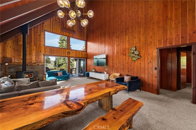 26834 Huron Rd, Lake Arrowhead, CA 92352 - living room with high vaulted ceiling, wood walls, carpet, a wood stove, and a chandelier