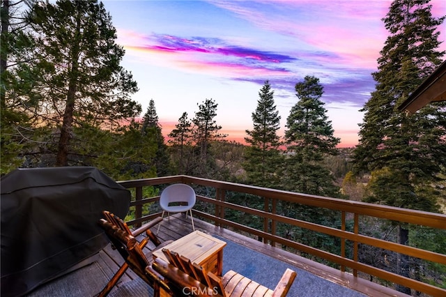 balcony at dusk featuring a grill