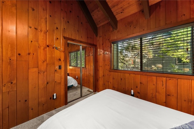 bedroom with wooden walls, lofted ceiling with beams, wood ceiling, and carpet