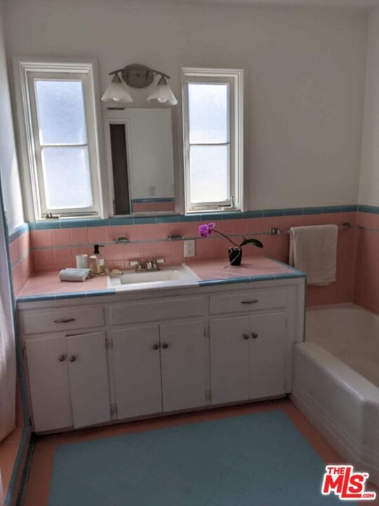 bathroom featuring a tub to relax in and vanity