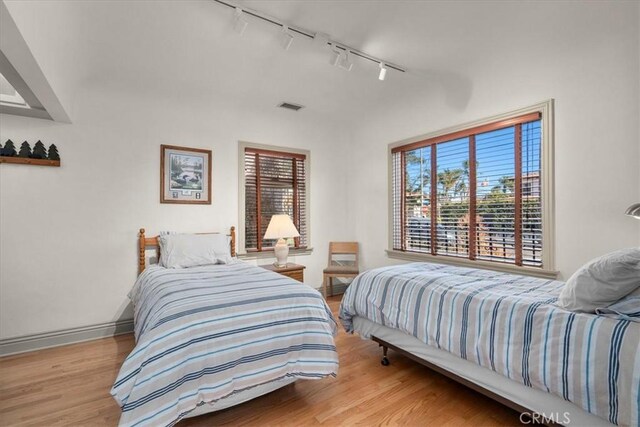 bedroom with vaulted ceiling and light hardwood / wood-style floors