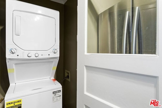 laundry area featuring stacked washer / drying machine