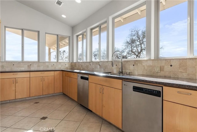 kitchen featuring vaulted ceiling, dishwasher, decorative backsplash, light tile patterned floors, and light brown cabinets