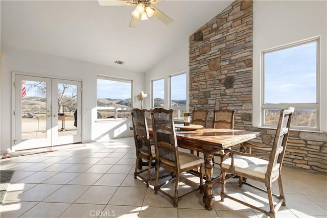 dining space with french doors, ceiling fan, lofted ceiling, and light tile patterned flooring