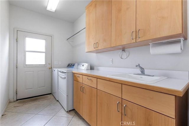 laundry room featuring cabinets, separate washer and dryer, sink, and light tile patterned floors