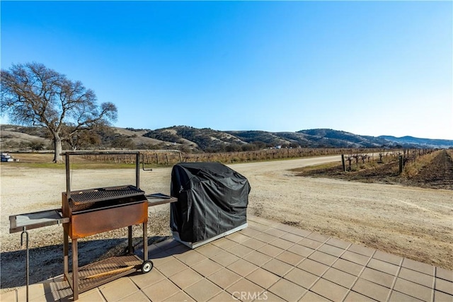 view of patio / terrace featuring a grill, a mountain view, and a rural view