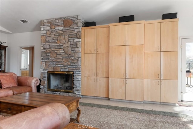 living room featuring light tile patterned flooring, lofted ceiling, and a fireplace