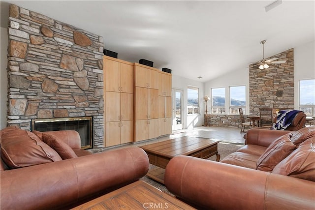 living room featuring a fireplace, ceiling fan, and vaulted ceiling