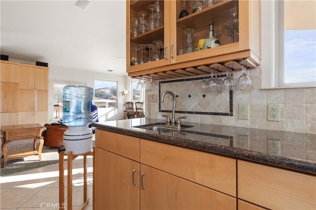 kitchen featuring tasteful backsplash, sink, and dark stone counters