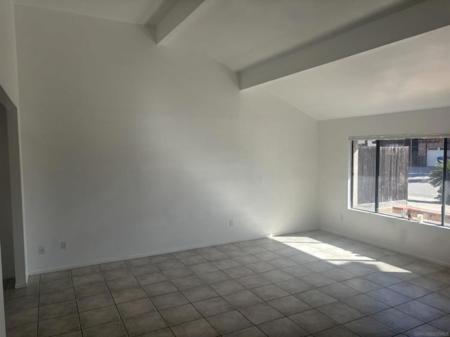 empty room with vaulted ceiling with beams and light tile patterned floors