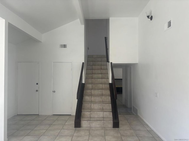 stairs featuring tile patterned flooring and lofted ceiling with beams