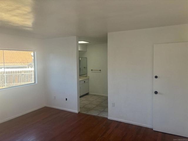 unfurnished bedroom with ensuite bathroom and light hardwood / wood-style flooring