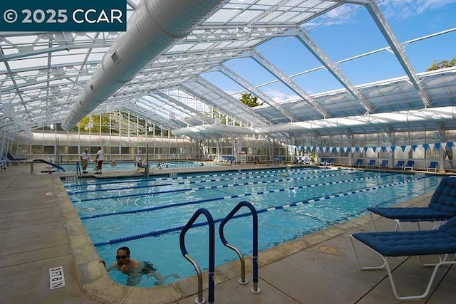 view of swimming pool with glass enclosure