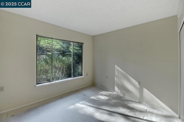 spare room with carpet floors and a textured ceiling