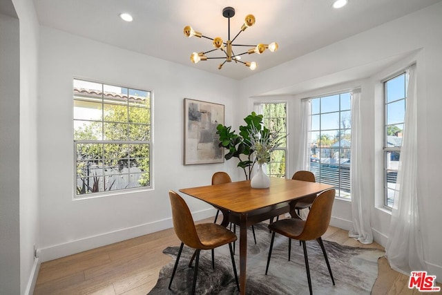 dining space featuring an inviting chandelier and light wood-type flooring