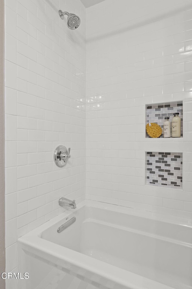 bathroom featuring tiled shower / bath