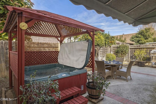 view of patio featuring a hot tub and a gazebo