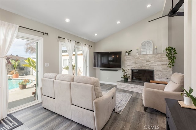 living room with lofted ceiling, hardwood / wood-style flooring, and a fireplace