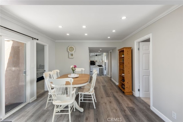 dining space with hardwood / wood-style flooring and ornamental molding