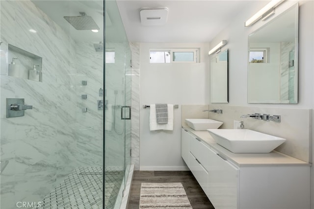 bathroom featuring tasteful backsplash, vanity, a shower with shower door, and hardwood / wood-style floors