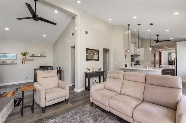 living room featuring ceiling fan, dark hardwood / wood-style floors, sink, and high vaulted ceiling