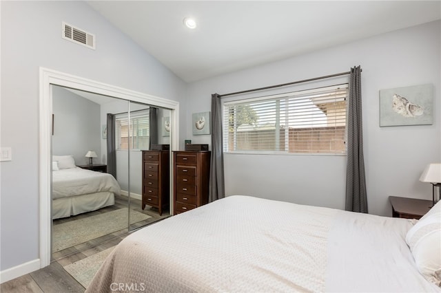 bedroom featuring vaulted ceiling, light hardwood / wood-style floors, and a closet