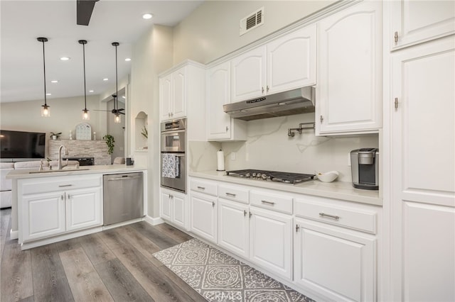 kitchen with white cabinetry, hanging light fixtures, kitchen peninsula, ceiling fan, and stainless steel appliances