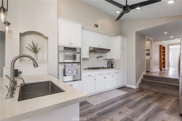 kitchen featuring appliances with stainless steel finishes, sink, white cabinets, ceiling fan, and dark wood-type flooring